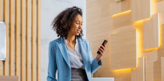 A woman viewing her American Express Rewards Checking account on her cell phone.