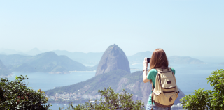 A traveler takes a photo of Sugarloaf Mountain in Rio De Janeiro, Brazil