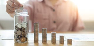 Jar of quarters with stacks of quarters