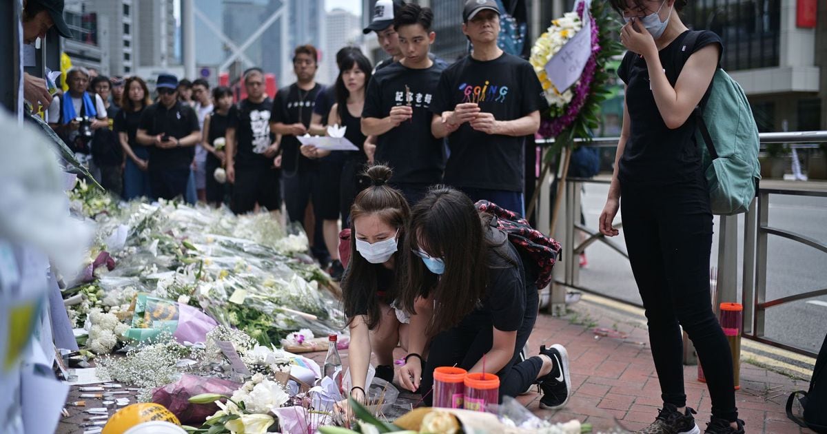 Fleurs et prières devant le lieu où est mort un opposant au projet de loi controversé autorisant les extraditions vers la Chine, à Hong Kong le 16 juin 2019