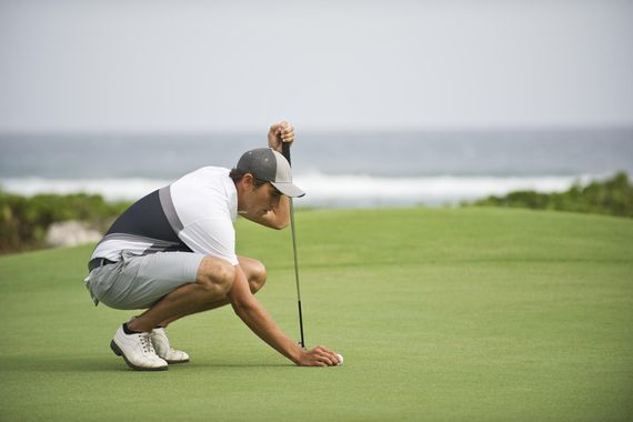 A golfer tees up his ball