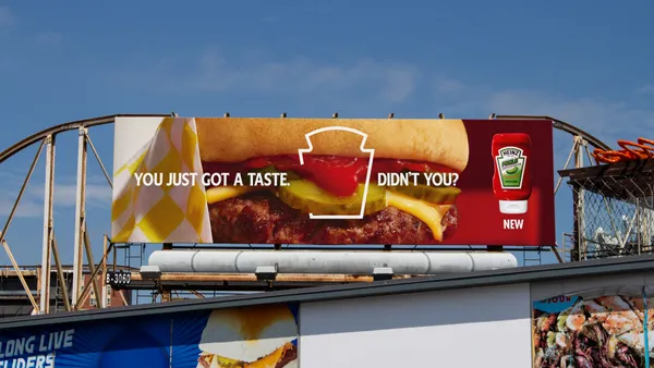 An outdoor billboard shows a closeup of a hamburger and reads "You just got a taste, didn't you?"