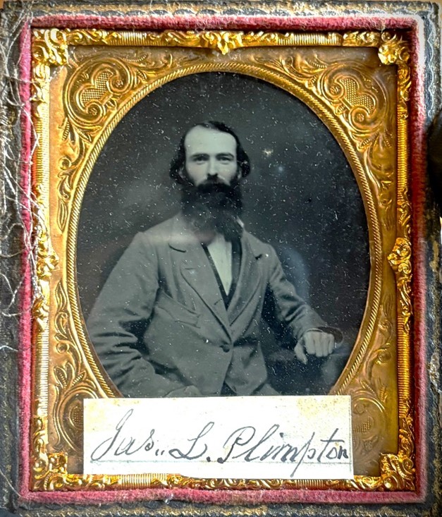 Ambrotype photo of James Plimpton wearing a suit and resting against one arm.