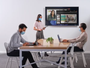 a group of people sitting at a table using a laptop