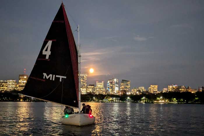 MIT sailboat on the water at night