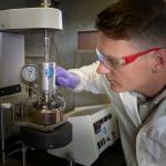 James Crawford looking intently at a piece of laboratory equipment