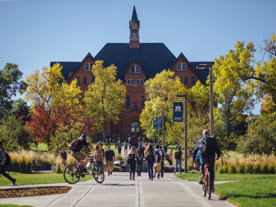 Students walking on campus with Montana Hall in the background | MSU file photo