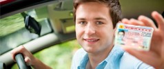 Man smiling and holding his drivers license