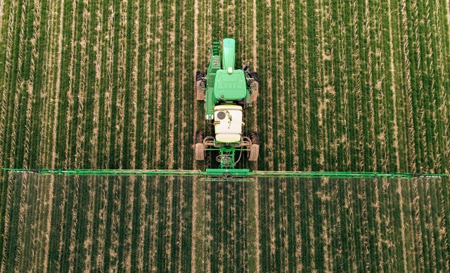 In a field in western Kentucky, a machine sprays cover crops