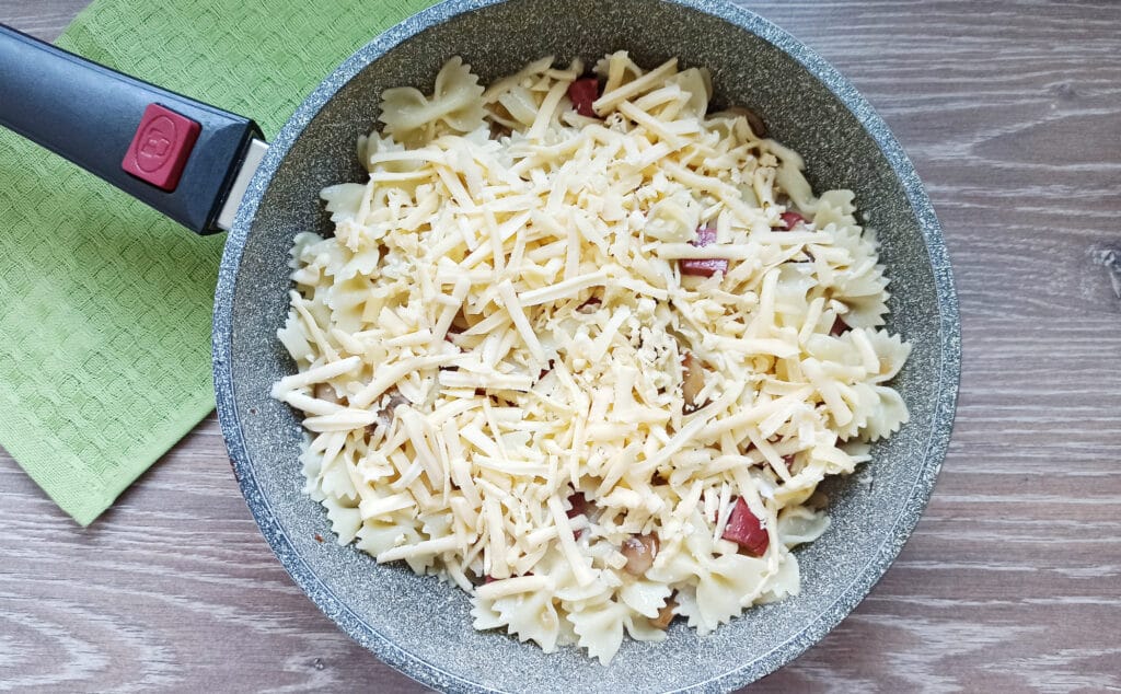 Фото рецепта - Макароны с грибами, колбасой и сыром на сковороде - шаг 7