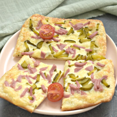 Пицца из слоёного теста с сырным соусом, колбасой и огурцами - рецепт с фото