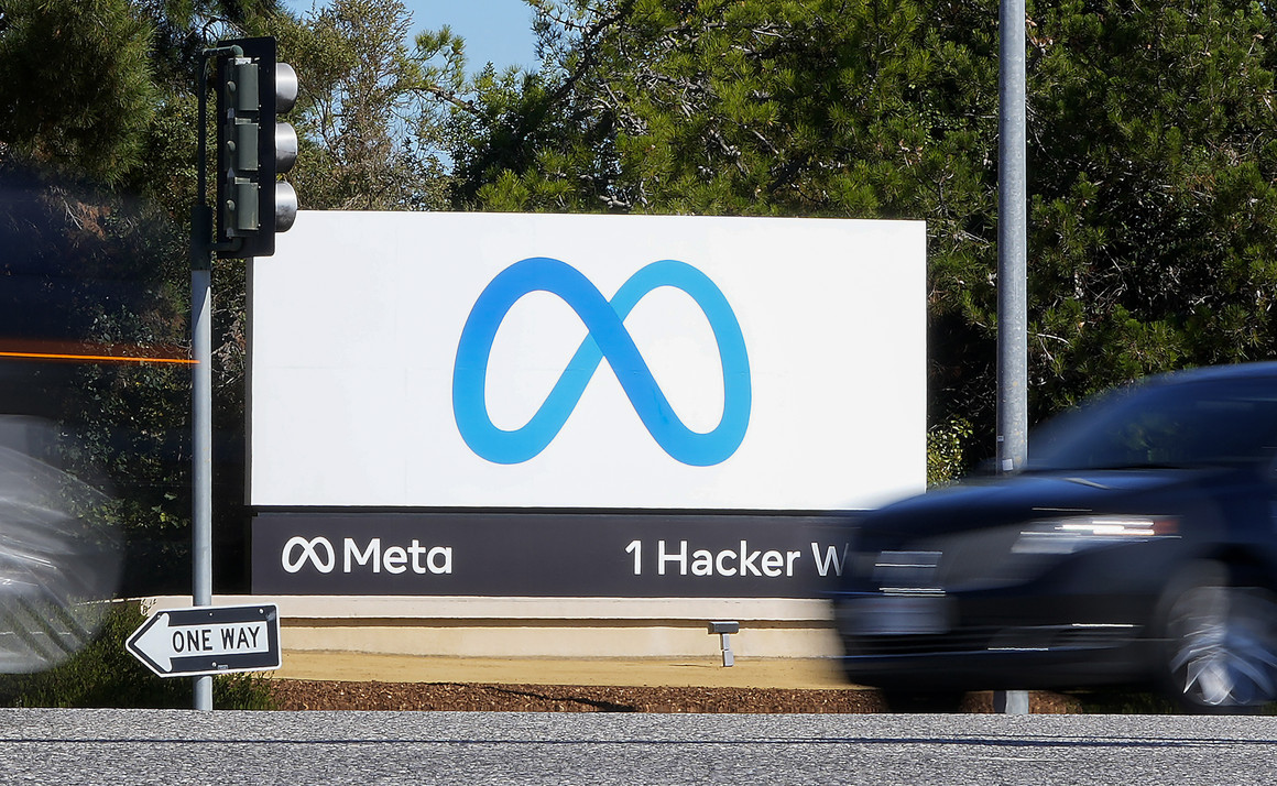 A car passes Facebook's new Meta logo on a sign at the company headquarters.