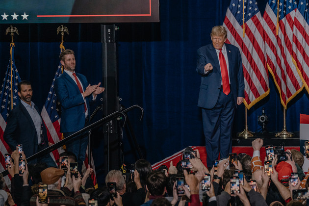 Republican presidential candidate Donald Trump walks on stage with his sons, Eric Trump and Donald Trump Jr., to speak at his caucus night victory event in Des Moines, Iowa.