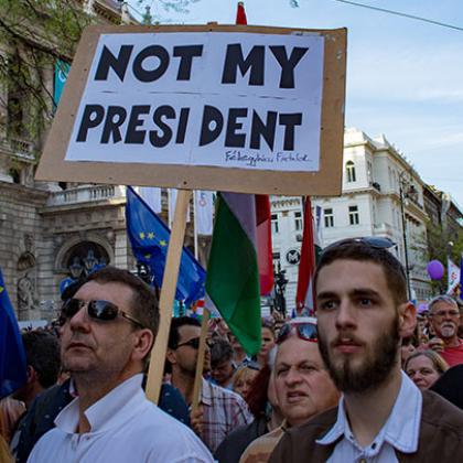 a group of protestors in Hungary holding placards and flags