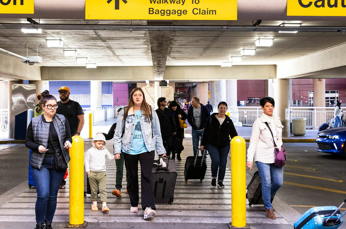 Arriving passengers walk to retrieve their vehicles from the level 2 of Terminal 1 parking lot ...