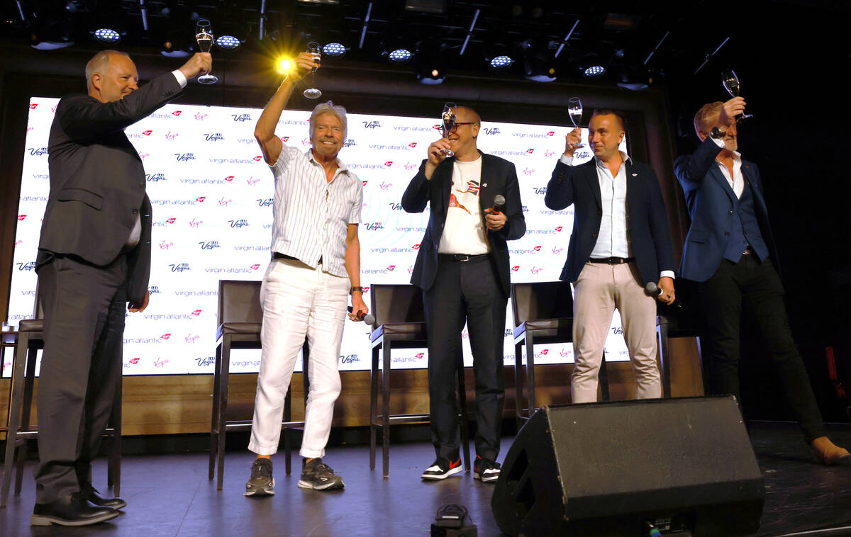 Sir Richard Branson, second from left, president and founder of Virgin Group, toasts, from left ...