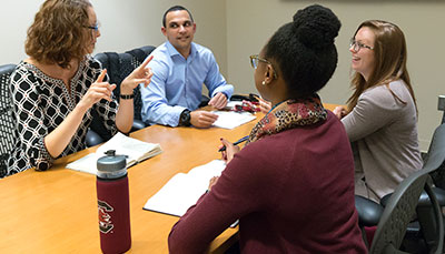 Group of people talking together at a conference room table.