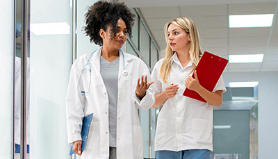 Two people in a medical environment talking to each other.