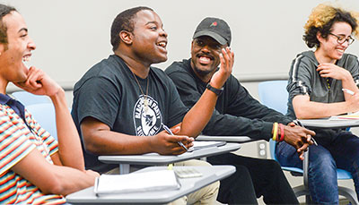 Group of students in a classroom laughing together. 