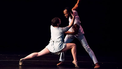 Two performers dancing together on stage.