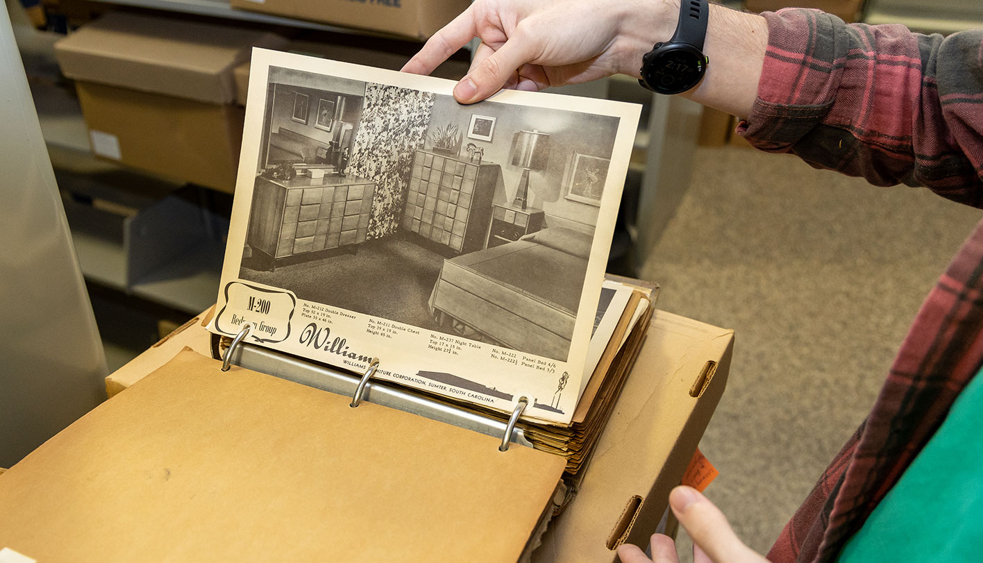 Person looking at historical photographs in a library.