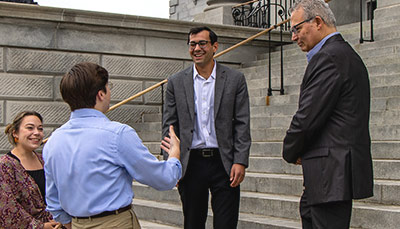 Group of people standing on the statehouse steps.