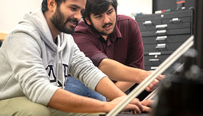 Two people examining a device.