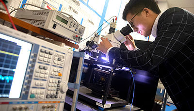 Person looking through a microscope.