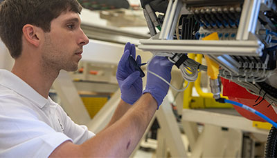 Student examining parts of a device.