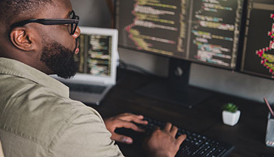 Person looking at a screen of code on a computer monitor.