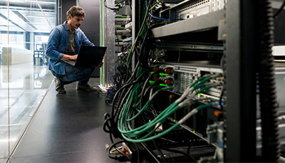 Person in a server room with a laptop.