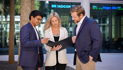 Group of business student standing outside in the courtyard at the Moore School.