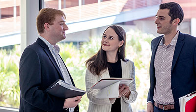 Group of business professionals talking in a hallway.