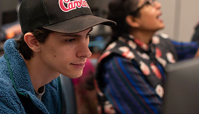 Student sitting at a table in a computer lab.