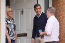 Prime Minister Rishi Sunak with local parliamentary candidate Paul Holmes (right) speaking to a voter during a canvassing session (Jonathan Brady/PA)