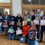 West Somerset Food Cupboard volunteers and Jennifer Duke, the high sheriff of Somerset (right) hold food bags.