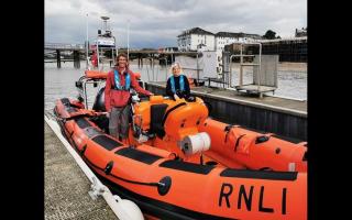 Adventurer Ed Pratt standing on Gravesend's Atlantic 85 with RNLI Commander Karla.