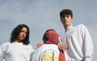 Students posing while wearing SSU Student Living merch