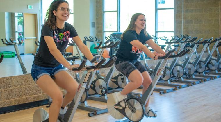 Students using the cycles in the Campus Recreation building