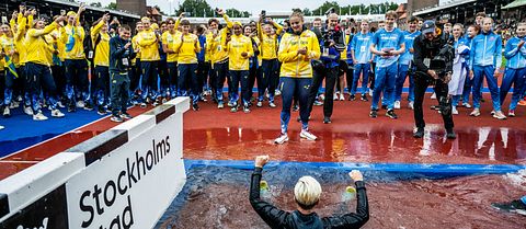 Svenska landslaget i friidrott kastar förbundskapten i vattengraven på Stockholm Stadion.