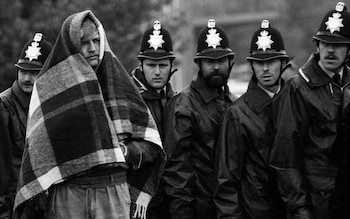 A striking miner stands in front of a line of police officers near the Orgreave plant