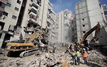 Emergency workers use excavators to clear the rubble at the site of Friday's Israeli strike in Beirut's southern suburbs