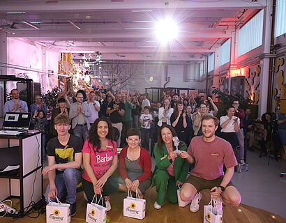 Gruppe von Menschen beim 3. Brandenburger Science Slam, zum Teil hockend und stehend, lachen alle in die Kamera