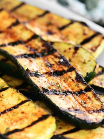 grilled zucchini on a white platter.