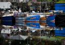 Stock image of fishing boats seen tied up at Tarbert Harbour in Scotland