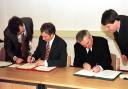 Former UK prime minister, Tony Blair, left, and Irish Taoiseach Bertie Ahern, right, signing The Northern Ireland Peace Agreement