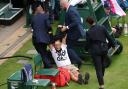 A protester is dragged off by security on court 18 after a Just Stop Oil protest using orange confetti and a jigsaw pieces