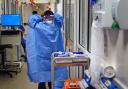 File photo of a nurse putting on full PPE on a ward for Covid patients