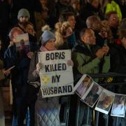 Protesters gather as Boris Johnson, Britain's former Prime Minister, leaves after giving evidence at the Covid Inquiry