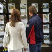 People outside an estate agent's window